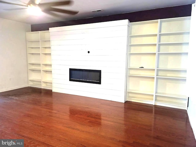 unfurnished living room featuring a fireplace, dark hardwood / wood-style floors, and ceiling fan