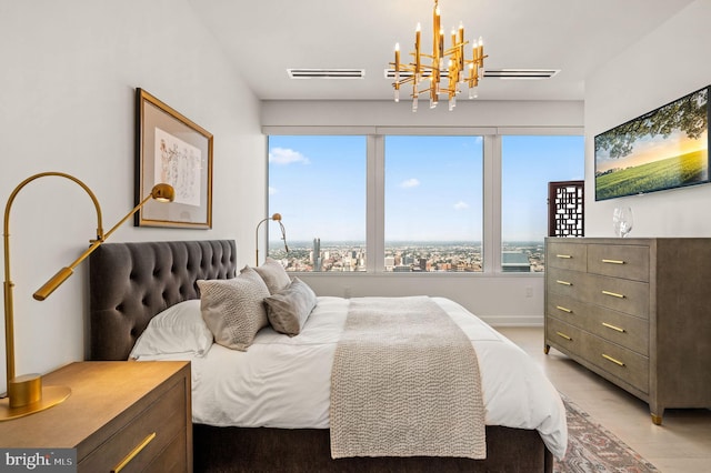 bedroom with light hardwood / wood-style flooring and an inviting chandelier