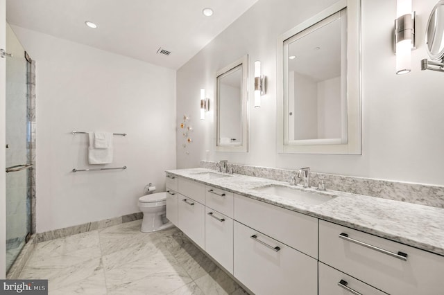 bathroom with vanity, toilet, and a shower with door