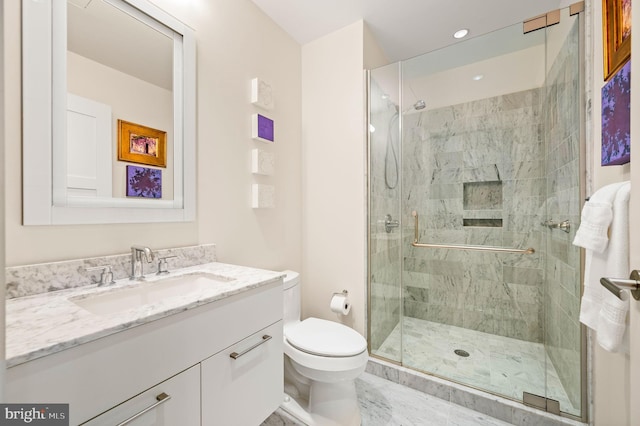 bathroom featuring vanity, toilet, and a shower with door