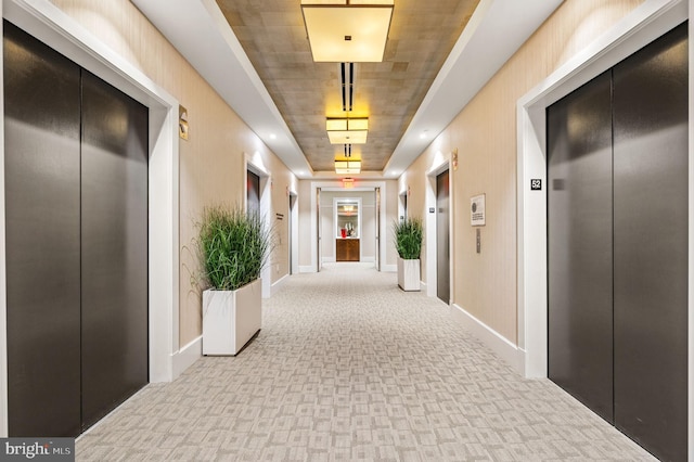 corridor with light carpet and elevator