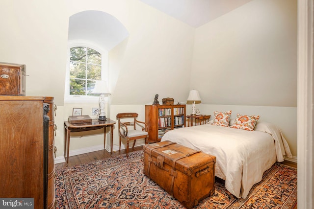 bedroom featuring hardwood / wood-style flooring and lofted ceiling