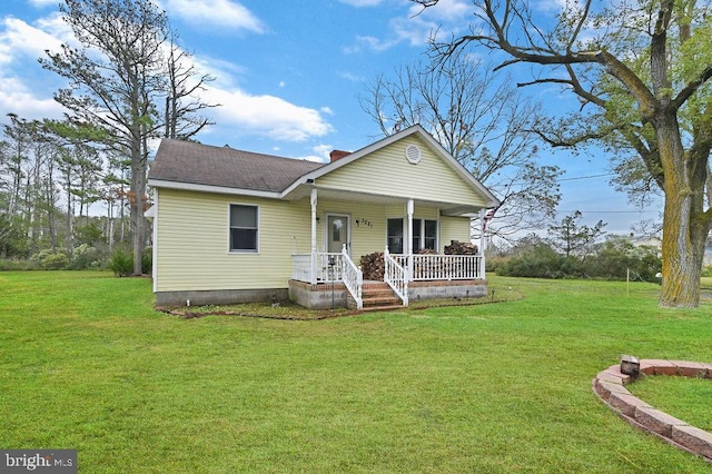 rear view of house with a lawn and a porch