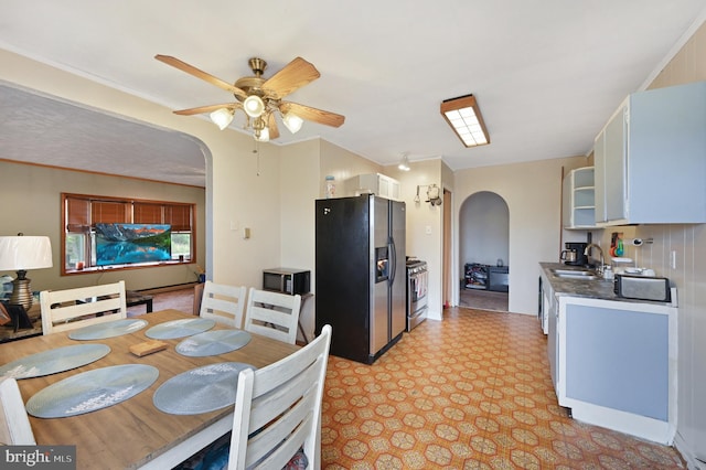 dining room featuring ceiling fan and sink