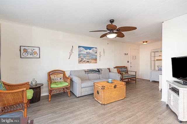 living room featuring ornamental molding, ceiling fan, and light hardwood / wood-style flooring