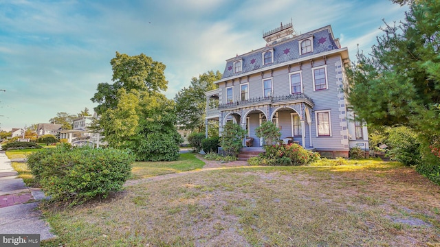 italianate home featuring a front lawn and covered porch