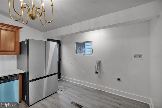 kitchen featuring a chandelier, light hardwood / wood-style floors, stainless steel appliances, backsplash, and decorative light fixtures