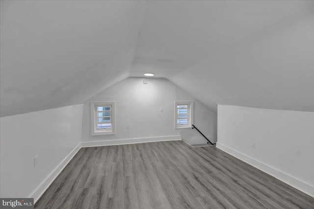 bonus room featuring light hardwood / wood-style flooring, lofted ceiling, and a healthy amount of sunlight