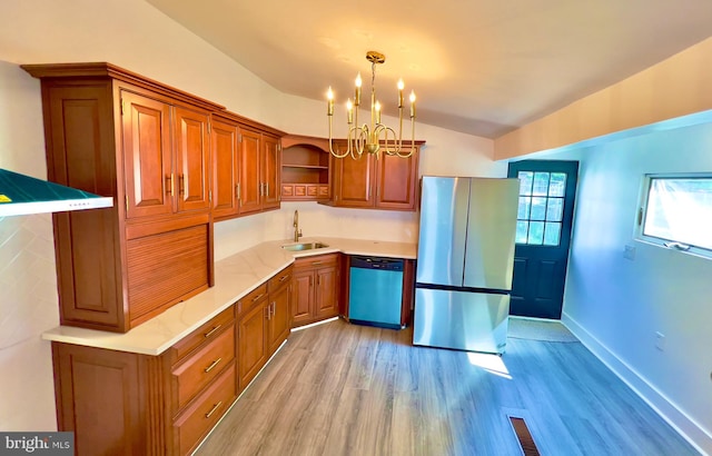 kitchen with pendant lighting, sink, vaulted ceiling, appliances with stainless steel finishes, and light hardwood / wood-style floors