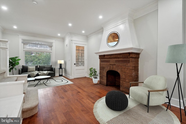 living room with crown molding, a fireplace, and hardwood / wood-style floors