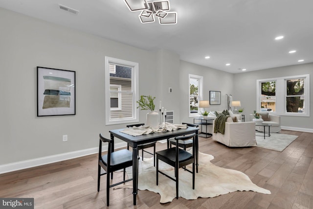 dining space with a notable chandelier and hardwood / wood-style floors