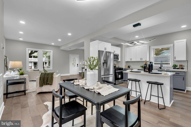 dining space featuring light hardwood / wood-style flooring and sink