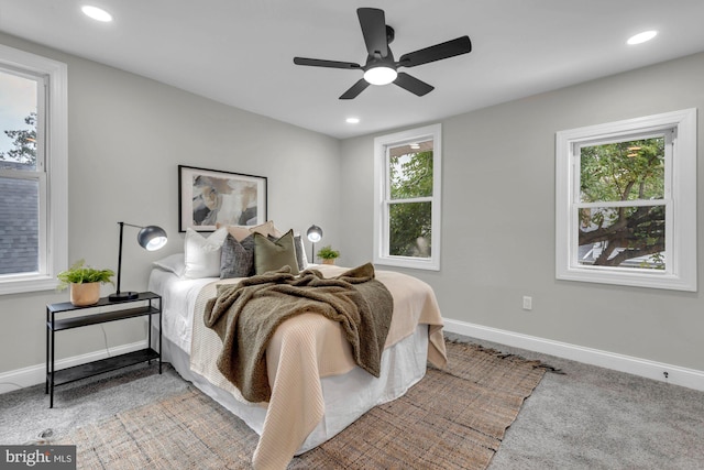 bedroom featuring carpet, ceiling fan, and multiple windows