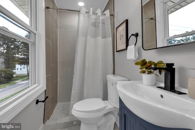 bathroom with vanity, plenty of natural light, curtained shower, and toilet