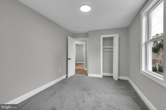 unfurnished bedroom featuring a closet, carpet flooring, and multiple windows