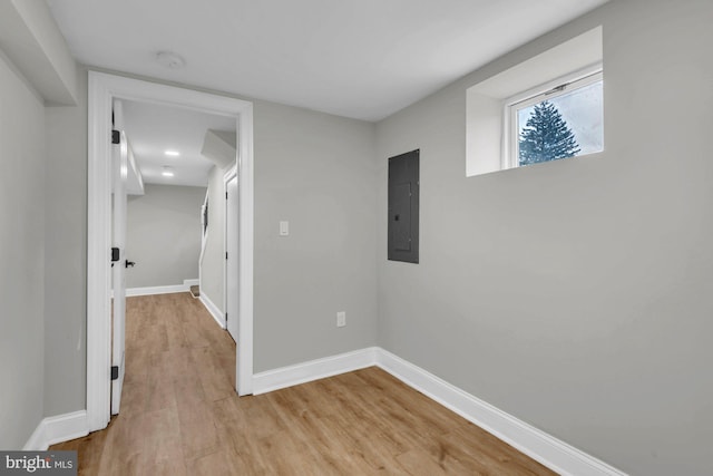 corridor featuring light hardwood / wood-style flooring and electric panel