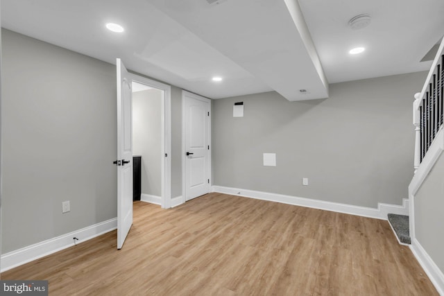 basement with light hardwood / wood-style flooring