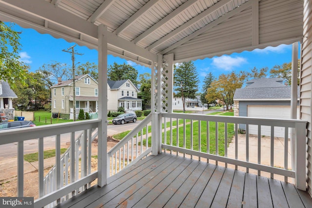 deck featuring a yard, a garage, and covered porch