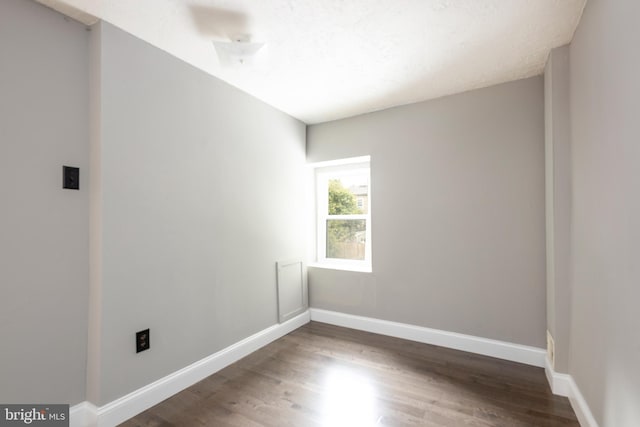 empty room with dark wood-type flooring