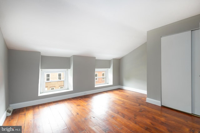 bonus room featuring a wealth of natural light and dark hardwood / wood-style flooring