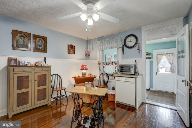 dining space with ceiling fan, a textured ceiling, and dark wood-type flooring