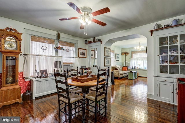 dining space featuring ceiling fan with notable chandelier and dark hardwood / wood-style floors