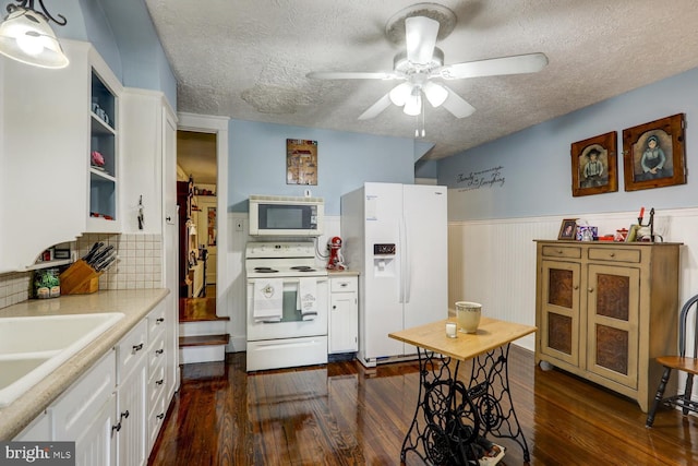 kitchen with a textured ceiling, dark hardwood / wood-style floors, tasteful backsplash, white cabinets, and white appliances