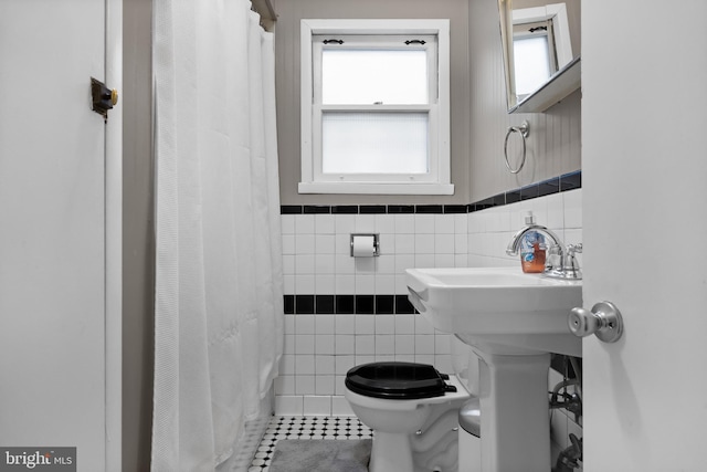 bathroom featuring shower / bath combination with curtain, tile walls, tile patterned flooring, and toilet