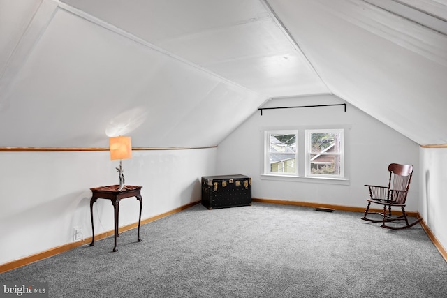 living area with lofted ceiling and carpet