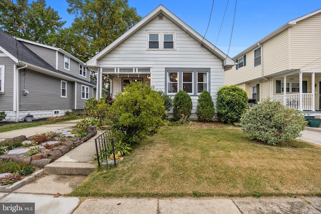 bungalow-style house with a front lawn and covered porch