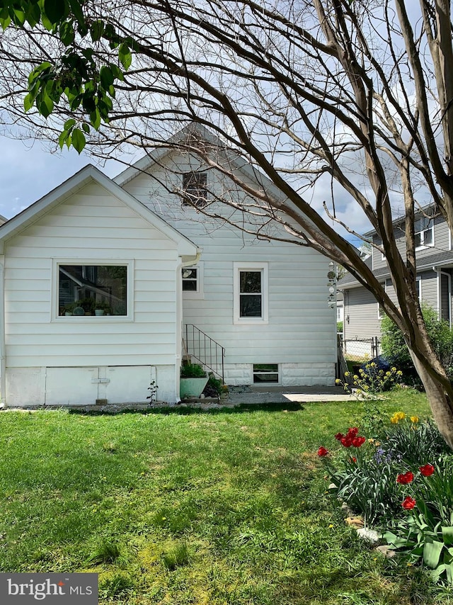 back of property featuring a lawn