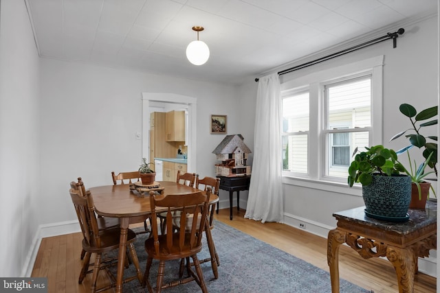 dining space featuring hardwood / wood-style flooring and crown molding