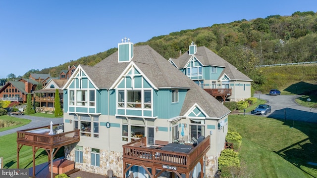 rear view of property with a deck and a yard