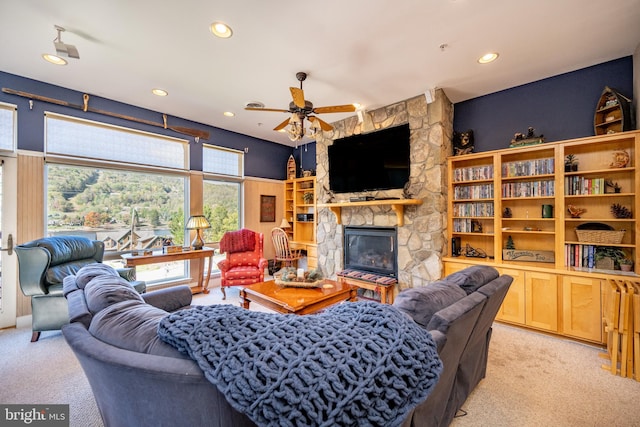 living room featuring light carpet, a fireplace, and ceiling fan