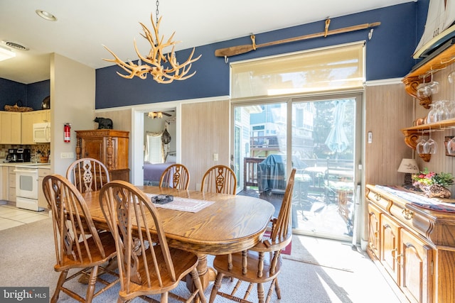 dining area with light carpet and a chandelier