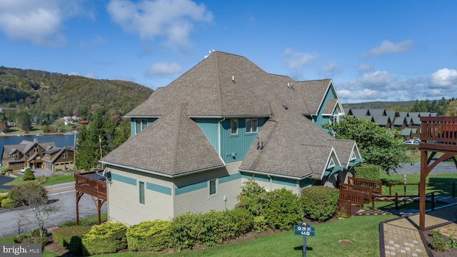 rear view of property featuring a wooden deck and a yard