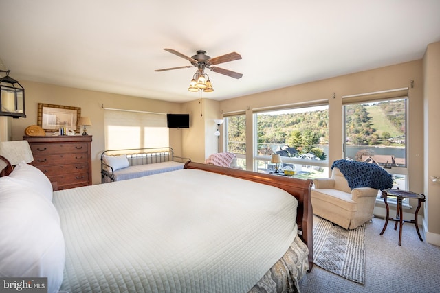 carpeted bedroom with ceiling fan and access to outside