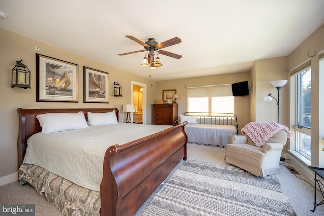 bedroom with multiple windows, light carpet, and ceiling fan