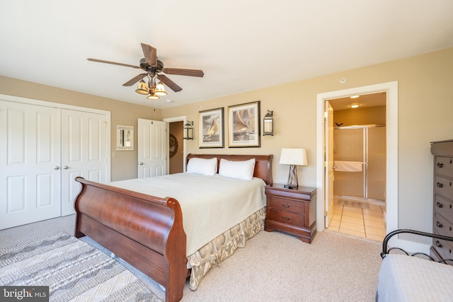 carpeted bedroom with ensuite bath, ceiling fan, and a closet