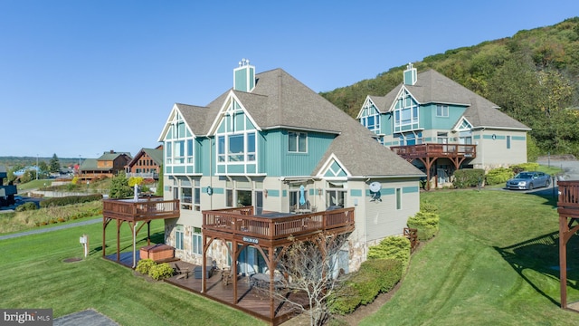 rear view of house featuring a yard and a wooden deck