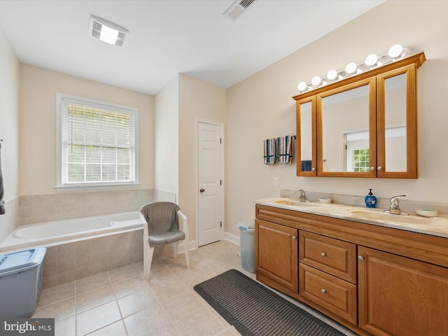 bathroom with tiled bath, tile patterned flooring, and vanity