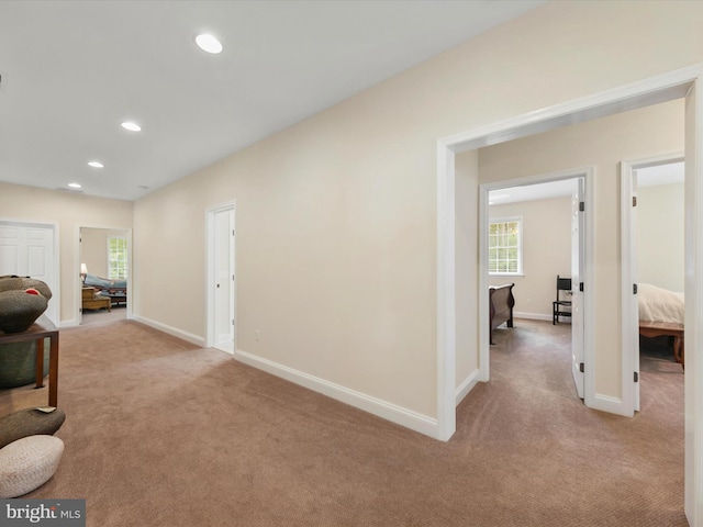 hallway featuring light colored carpet