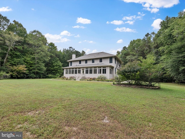 back of property featuring a lawn and a sunroom