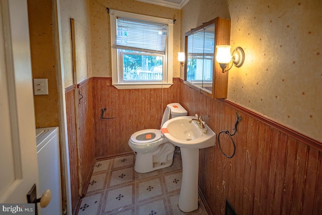 bathroom with ornamental molding, wooden walls, and toilet