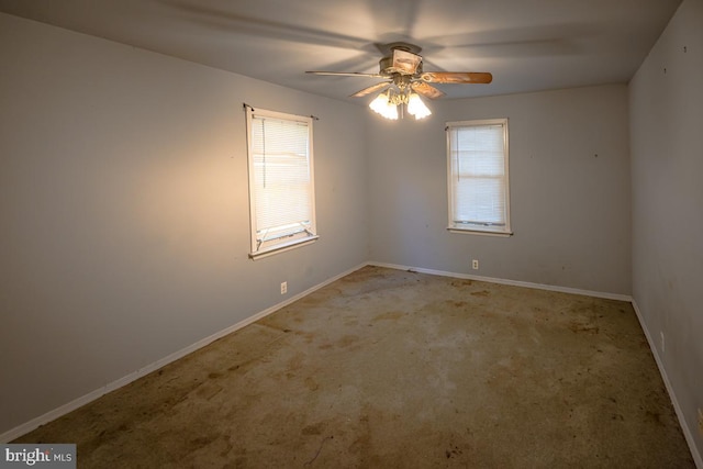 carpeted spare room featuring ceiling fan