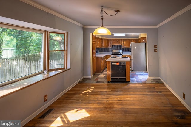 kitchen with decorative backsplash, a kitchen island, pendant lighting, stainless steel appliances, and dark hardwood / wood-style floors