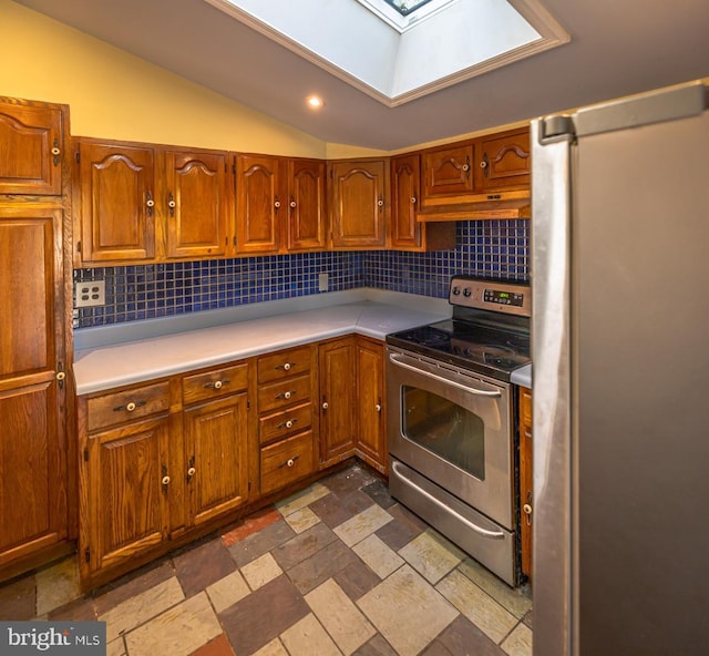 kitchen featuring decorative backsplash, vaulted ceiling with skylight, appliances with stainless steel finishes, and premium range hood