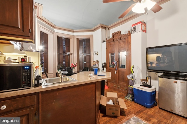 kitchen with ceiling fan, sink, crown molding, and hardwood / wood-style floors