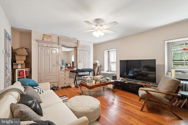 living room with wood-type flooring, radiator, and ceiling fan