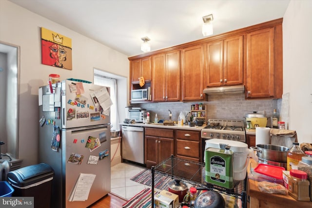 kitchen featuring light tile patterned floors, sink, stainless steel appliances, and tasteful backsplash